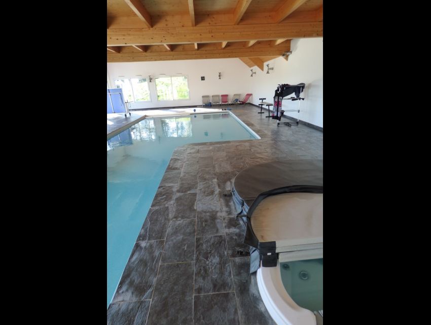 Masion avec piscine couverte intérieure, jacuzzi et sauna.