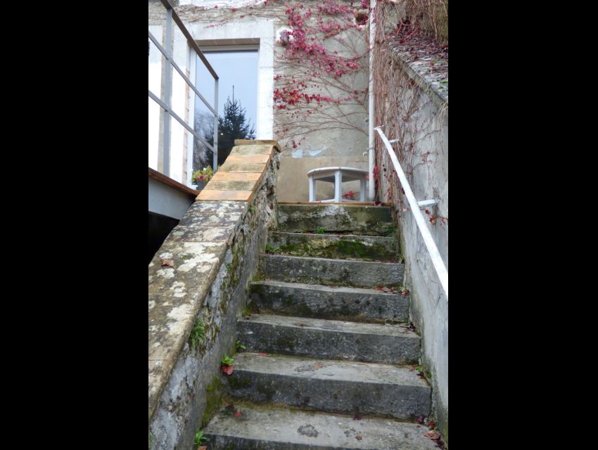 Escalier extérieur  avec marches en pierre formant liaison entre maison et jardin