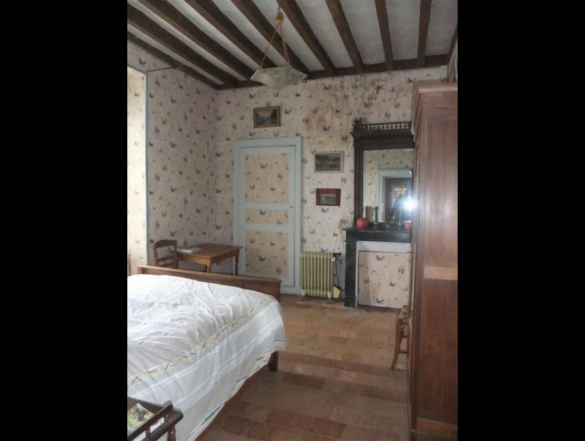 Belle demeure XIXème siècle - Propriété villageoise à restaurer - Secteur Sablé sur Sarthe - Vue d'une des chambres, carrelée de tomettes avec poutres apparentes et cheminée. 
