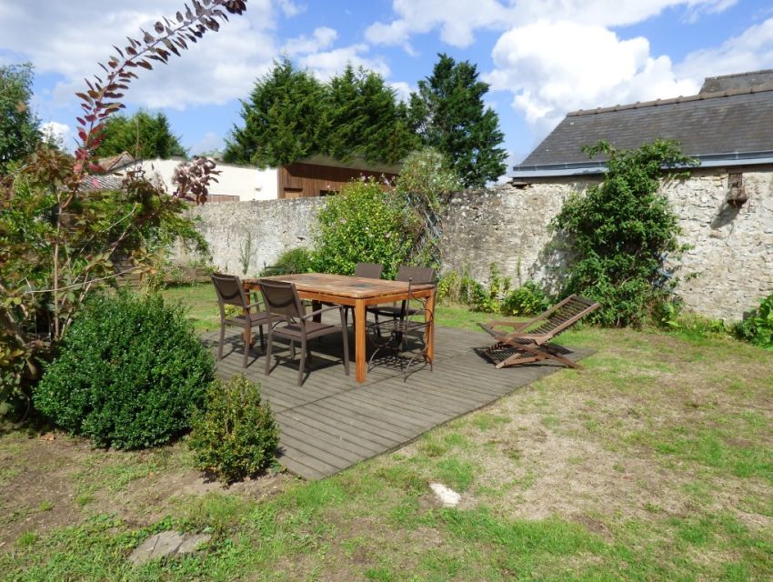 Près de Sablé-sur-Sarthe, maison villageoise avec jardin clos, garage et dépendance.