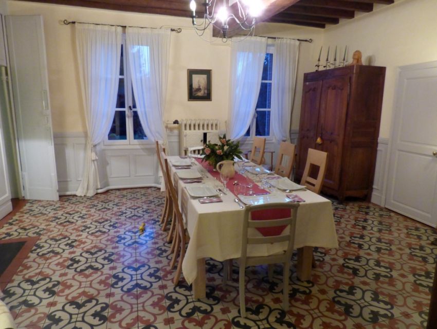 Grande salle à manger avec carrelage à l'italienne cheminée en marbre et poutraison