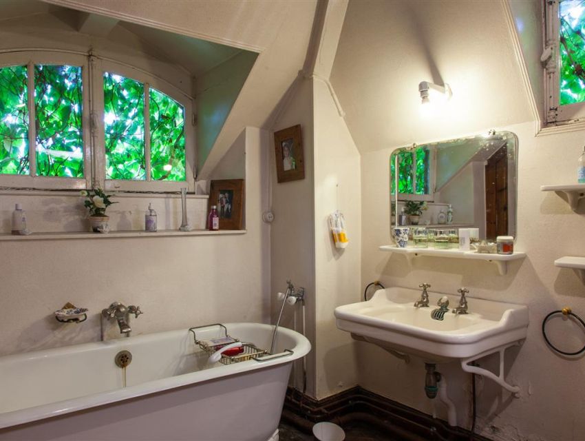 salle de bains parquetée équipée d'authentiques éléments (baignoire en fonte, vasque en porcelaine ...)