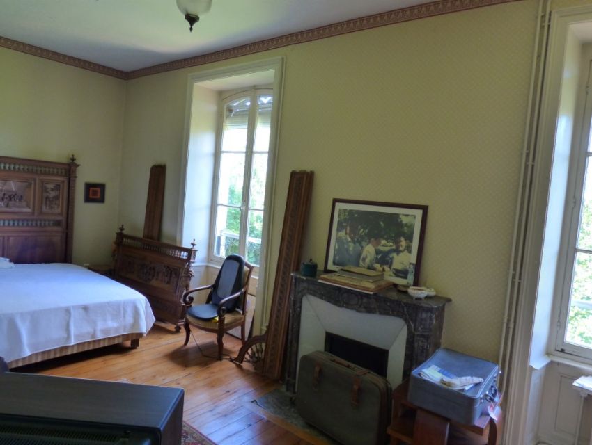 chambre parquetée avec cheminée et  éclairée sur le jardin 